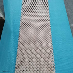 a wooden lattice with a blue plastic sheet covering it, placed on a blue surface.