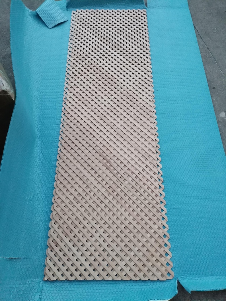 a wooden lattice with a blue plastic sheet covering it, placed on a blue surface.