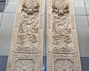May include: Two rectangular wooden panels with intricate carvings. Each panel features a detailed dragon design, floral patterns, and decorative borders. The carvings are in a natural wood tone, showcasing the craftsmanship.