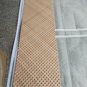 a wooden lattice board with a lattice pattern, placed on a white surface.