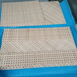 several pieces of woven material, likely a type of textile or textile-like material, arranged on a blue surface.