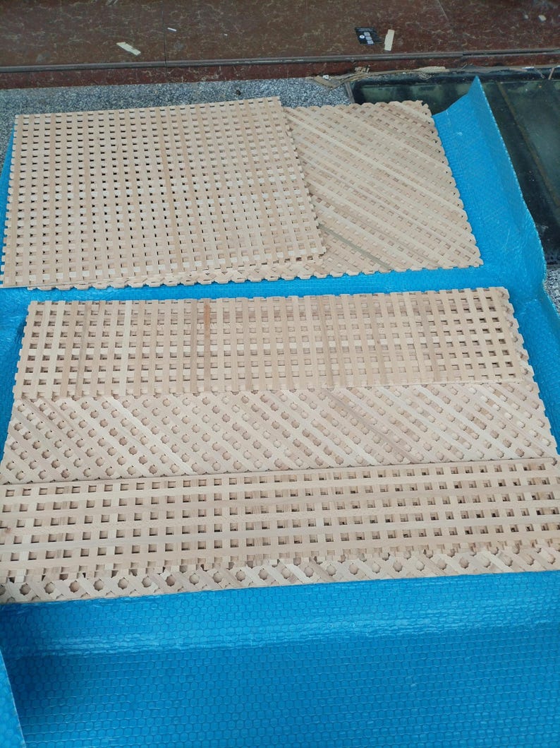 several pieces of woven material, likely a type of textile or textile-like material, arranged on a blue surface.