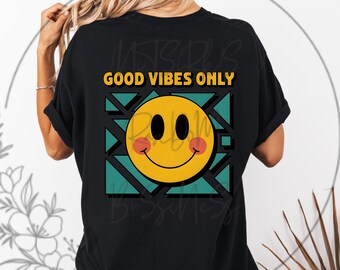May include: Black t-shirt with the text "GOOD VIBES ONLY" above a yellow smiley face with pink cheeks. The smiley face is set against a teal and black geometric design.