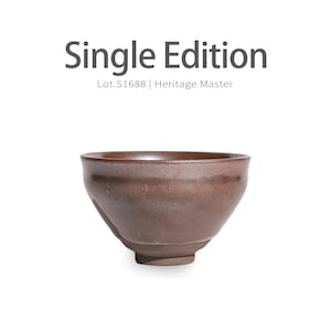 Può includere: Una ciotola in ceramica marrone con un bordo largo e un corpo leggermente affusolato. La ciotola ha una superficie strutturata e una base piccola e arrotondata. Il testo "Single Edition" e "Lot.S1688 | Heritage Master" sono sopra la ciotola.