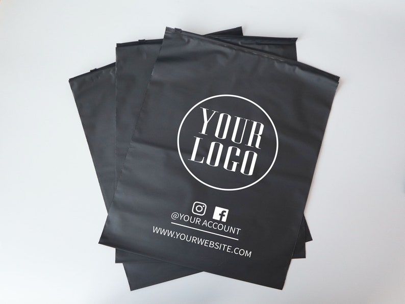 Op de afbeelding: Een stapel zwarte poly mailers met een wit cirkelvormig logo met de tekst "YOUR LOGO" en de tekst "@YOUR ACCOUNT" en "WWW.YOURWEBSITE.COM" onder het logo.