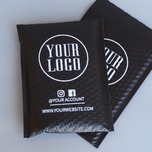 May include: Two black padded mailing envelopes with a white circle logo that says "YOUR LOGO" and the text "@YOUR ACCOUNT" and "WWW.YOURWEBSITE.COM".