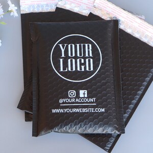 May include: Black padded mailing envelopes with a white circle logo that says "YOUR LOGO" and the text "@YOUR ACCOUNT" and "WWW.YOURWEBSITE.COM".