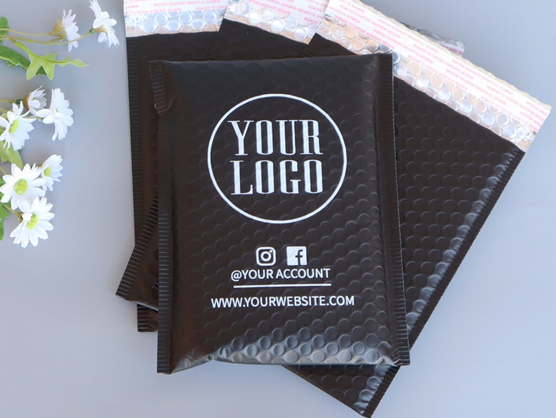 May include: Black padded mailing envelopes with a white circle logo that says "YOUR LOGO" and the text "@YOUR ACCOUNT" and "WWW.YOURWEBSITE.COM".