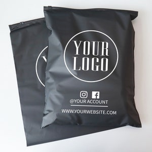 Op de afbeelding: Twee zwarte poly mailers met een wit cirkelvormig logo met de tekst "YOUR LOGO" en de tekst "@YOUR ACCOUNT" en "WWW.YOURWEBSITE.COM" onder het logo.