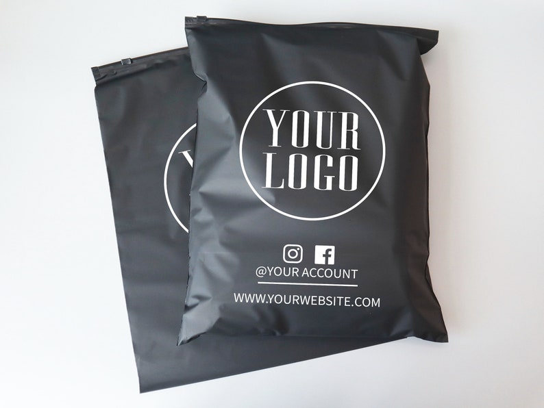 Op de afbeelding: Twee zwarte poly mailers met een wit cirkelvormig logo met de tekst "YOUR LOGO" en de tekst "@YOUR ACCOUNT" en "WWW.YOURWEBSITE.COM" onder het logo.