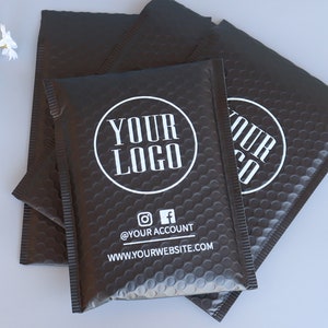 May include: Black padded mailing envelopes with a white circle logo that says "YOUR LOGO" and the text "@YOUR ACCOUNT" and "WWW.YOURWEBSITE.COM".