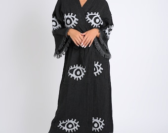May include: A black robe with white eye designs. The robe has a long, flowing silhouette and a tie belt. The robe is made of a soft, comfortable fabric.