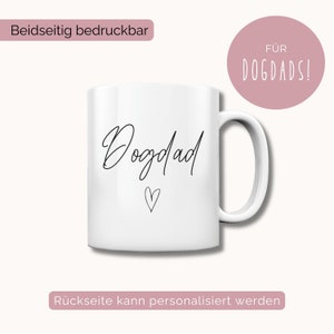 Puede incluir: Taza de cer&aacute;mica blanca con texto negro que dice "Dogdad" con un peque&ntilde;o coraz&oacute;n debajo. El texto "For Dogdads!" est&aacute; en un c&iacute;rculo rosa en la parte superior de la imagen. El texto "Beidseitig bedruckbar" est&aacute; en la parte superior izquierda de la imagen. El texto "R&uuml;ckseite kann personalisiert werden" est&aacute; en la parte inferior de la imagen.