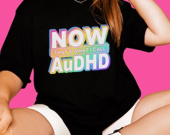 May include: A black t-shirt with a rainbow graphic that says "NOW THAT'S WHAT I CALL AuDHD".