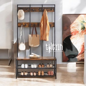 May include: A black metal coat rack with a wooden shelf and shoe storage. The rack has multiple hooks for hanging coats, hats, and bags. The shelf is made of wood with a rustic finish. The shoe storage has three tiers of wire shelves. The rack is standing in a room with a light brown floor.