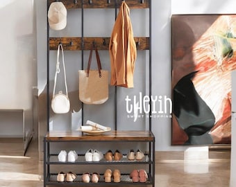 May include: A black metal coat rack with a wooden shelf and shoe storage. The rack has multiple hooks for hanging coats, hats, and bags. The shelf is made of wood with a rustic finish. The shoe storage has three tiers of wire shelves. The rack is standing in a room with a light brown floor.