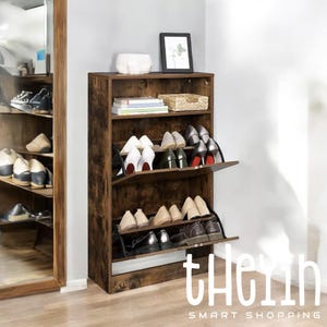 K&ouml;nnte beinhalten: Ein braunes Schuhregal aus Holz mit drei Regalbrettern. Die Regalbretter sind mit Schuhen gef&uuml;llt, darunter High Heels, Ballerinas und Sneakers. Das Schuhregal hat eine abgenutzte Oberfl&auml;che und einen Metallrahmen. Das Schuhregal ist unten rechts mit "the" beschriftet.