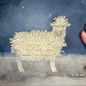 Op de afbeelding: Handgemaakte kaart met een schapenillustratie. Het schaap heeft een pluizig, getextureerd wollen lichaam tegen een aquarelachtergrond van een sterrenhemel. De kaart is gesigneerd "Machichmal HANDMADE".