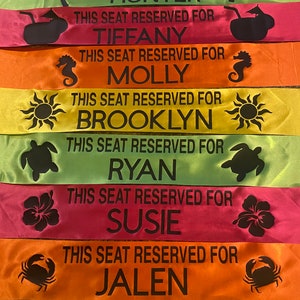 May include: A collection of colorful satin ribbons, each with the text "THIS SEAT RESERVED FOR" followed by a name. Each ribbon has a different tropical-themed graphic, such as sunglasses, palm trees, and sea creatures.