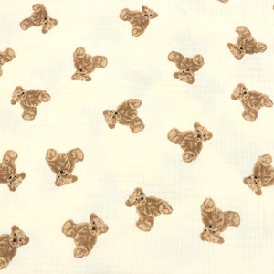 May include: A white fabric with a repeating pattern of brown teddy bears. The bears are all facing the same direction and are in various positions.