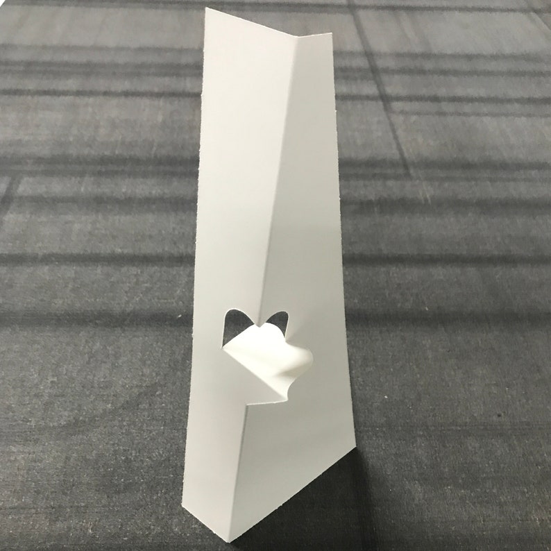 May include: White cardboard display stand with a cut-out for a sign or card. The stand is designed to be folded into a triangular shape.