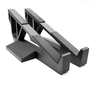 May include: A white ceramic mug with a black handle and the text "But First, Coffee" in a black, handwritten-style font. The mug is on a white surface.