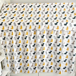 May include: A white fabric canopy with a dinosaur print in black, gray, and yellow. The canopy is made of a soft, lightweight fabric and is perfect for creating a cozy and fun play space for children.