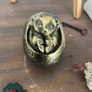 Goldene schwarze Igelskulptur in Gipskugel Bild 1