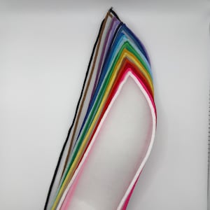 Puede incluir: Un abanico de tiras de tela transparentes y coloridas. Los colores incluyen negro, marrón, morado, azul, verde, amarillo, rojo, rosa y blanco. La tela parece ligera, posiblemente para manualidades o decoración.