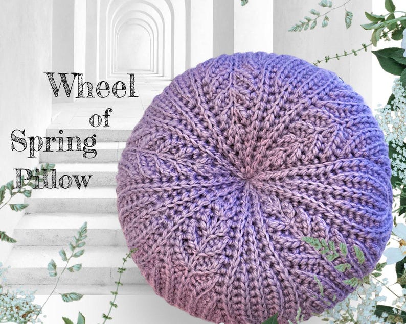 May include: A purple and pink crocheted cushion with a wheel-like design. The cushion is called "Wheel of Spring Pillow".