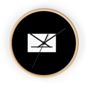 May include: Round wall clock with a black face and a light wood frame. The clock features a white rectangle with a black geometric design in the center. Black clock hands indicate the time. A simple, modern design.