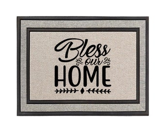 May include: A black and white doormat with the text "Bless our HOME" in a decorative font. The doormat has a gray and black border.
