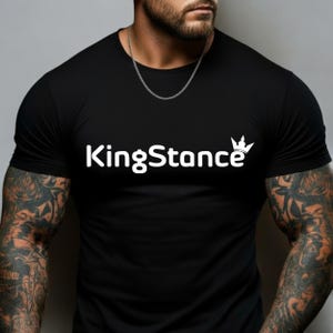 May include: Black crew neck t-shirt with the white text "KingStance" and a crown graphic. The shirt is made of a soft material and is a casual wear item.