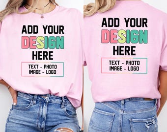 以下が含まれることがあります： ADD YOUR DESIGN HEREという黒い文字がプリントされたライトピンクのTシャツ。DESIGNの文字はカラフルで、その下にTEXT - PHOTO IMAGE - LOGOと書かれた長方形の枠があります。前面と背面の様子です。