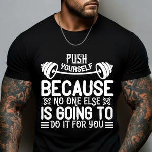 May include: Black t-shirt with a white graphic that reads "PUSH YOURSELF BECAUSE NO ONE ELSE IS GOING TO DO IT FOR YOU." The design includes a barbell and stylized text. The shirt is short-sleeved.