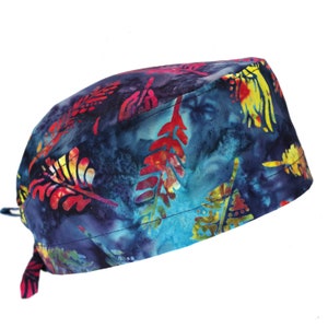 Op de afbeelding: Een blauwe, rode, gele en groene gepatroneerde chirurgische scrub-muts met een strik aan de achterkant.