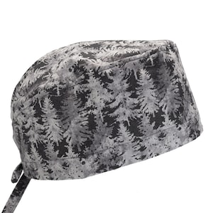 May include: A gray and black scrub hat with a pine tree pattern. The hat has a tie on the back.