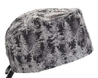Pode incluir: Um gorro de cirurgia cinza e preto com um padrão de pinheiros. O gorro tem um laço na parte de trás.