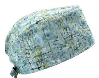 Pode incluir: Um gorro cirúrgico azul e verde estampado com uma gravata. O gorro é feito de um tecido macio e respirável.