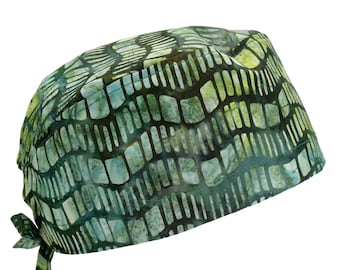 Pode incluir: Um gorro cirúrgico verde e branco estampado com uma gravata. O padrão é um desenho geométrico de quadrados e linhas.