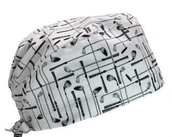 May include: A white scrub hat with a black and white pattern of golf clubs. The hat has a tie at the back.