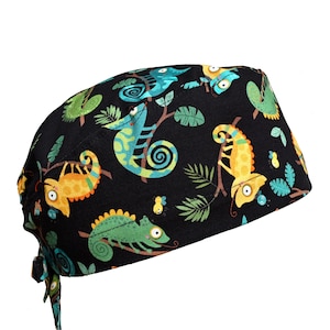 May include: Black scrub cap with a colorful pattern of cartoon chameleons in shades of yellow, green, and blue. The chameleons are perched on branches with green leaves. The cap has a tie closure.