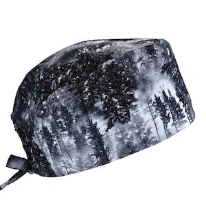 May include: A black and white patterned scrub cap featuring a forest scene. The cap has a tie closure at the back and is made of a soft, flexible material. The forest design includes tall trees and a misty background.