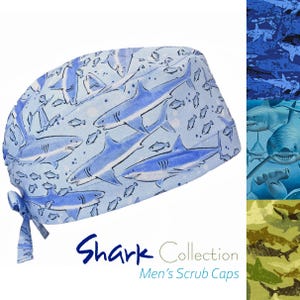 Op de afbeelding: Een lichtblauwe operatiemuts met een herhalend patroon van diverse haaien en kleine vissen in blauw- en wittinten. De muts heeft een striksluiting aan de achterkant. De tekst Shark Collection Men's Scrub Caps is onderaan zichtbaar.
