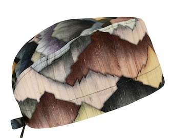 Può includere: Una cuffia da sala operatoria con un motivo astratto multicolore di forme geometriche sovrapposte in tonalità marrone, nero, crema e viola tenue. Il tessuto presenta una sottile trama venata simile al legno e lacci per la chiusura.