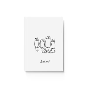 May include: A white notebook featuring a black line drawing of five cats and the word "cats" in a handwritten style. The name "Richard" is printed below the illustration.