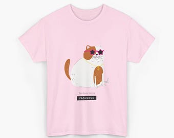 Può includere: T-shirt rosa chiaro con un gatto dei cartoni animati con occhiali da sole e una catena d'oro. Il gatto è bianco e marrone, con la scritta "Too busy being FABULOUS" sotto.