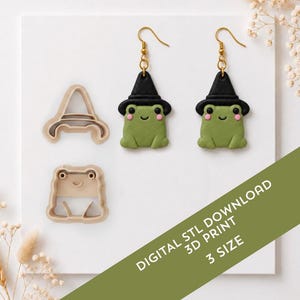 Puede incluir: Un par de pendientes de rana con sombreros de bruja negros y dos cortadores de galletas de plástico beige con forma de rana y sombrero. El texto dice DIGITAL STL DOWNLOAD 3D PRINT 3 SIZE. Los pendientes tienen mejillas rosas y ganchos dorados.
