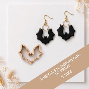 May include: A pair of black bat-shaped earrings with gold-toned metal hooks and circular connectors, accompanied by a beige bat-shaped cookie cutter. The image includes the text: DIGITAL STL DOWNLOAD 3D PRINT 5 SIZE.