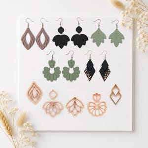 Puede incluir: Una colección de pendientes hechos a mano en varios diseños y colores. Los pendientes incluyen formas de lágrima, hoja y geométricas en tonos marrón, negro y verde. También se muestran cortadores de pendientes en melocotón.